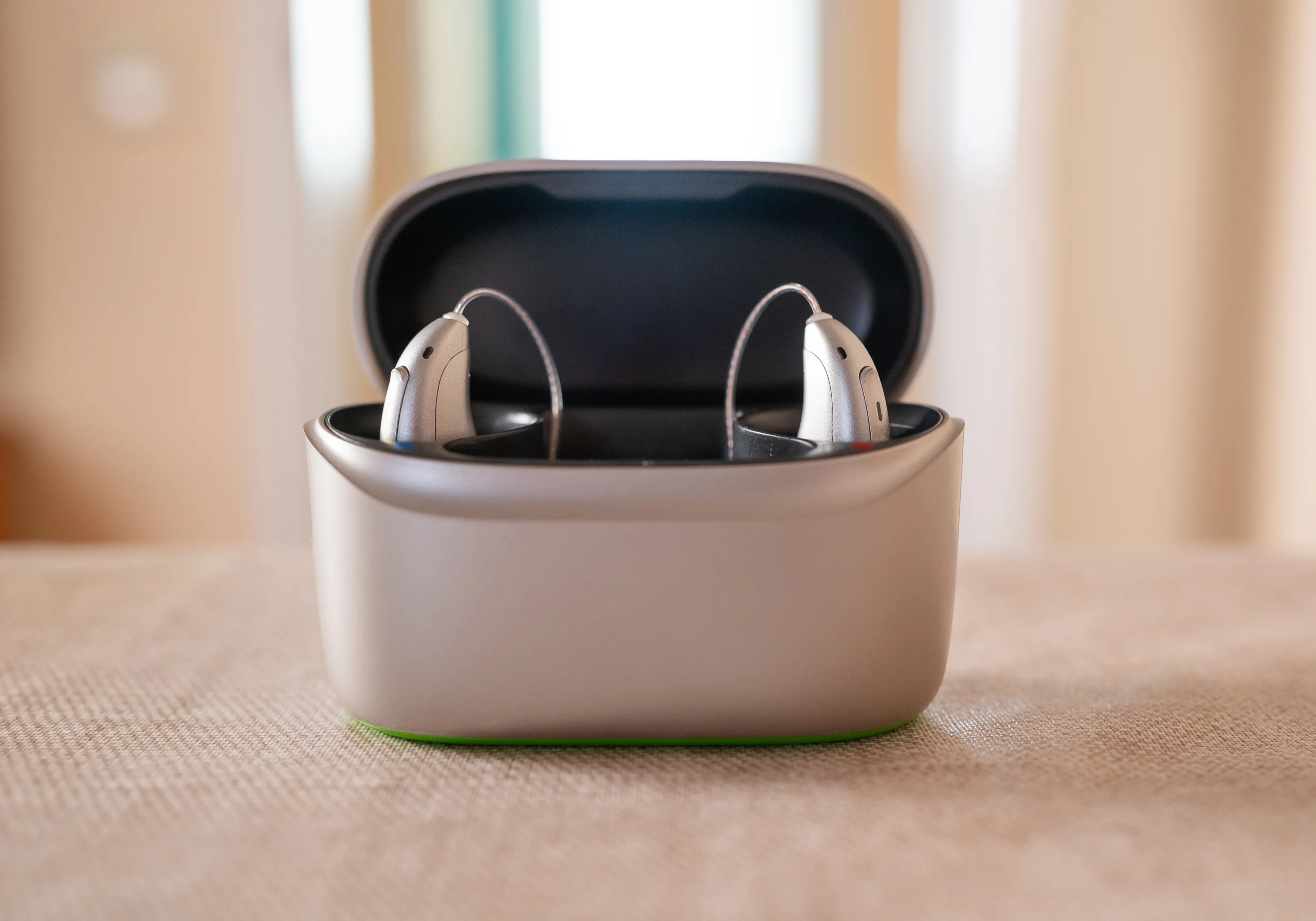 Modern discreet hearing aids resting in a compact wireless charging case